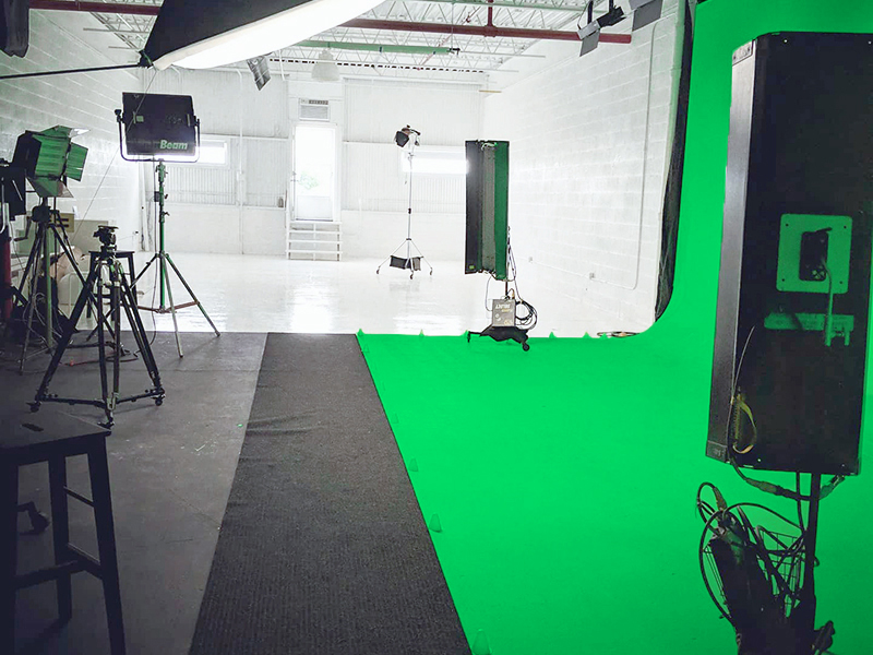 a picture of green screen and white studio with softbox kino flo lights c stands stool