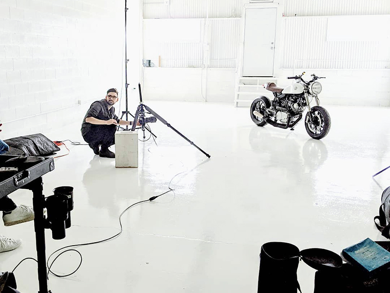 a picture of motorcycle photography in a white studio with photographer camera lights